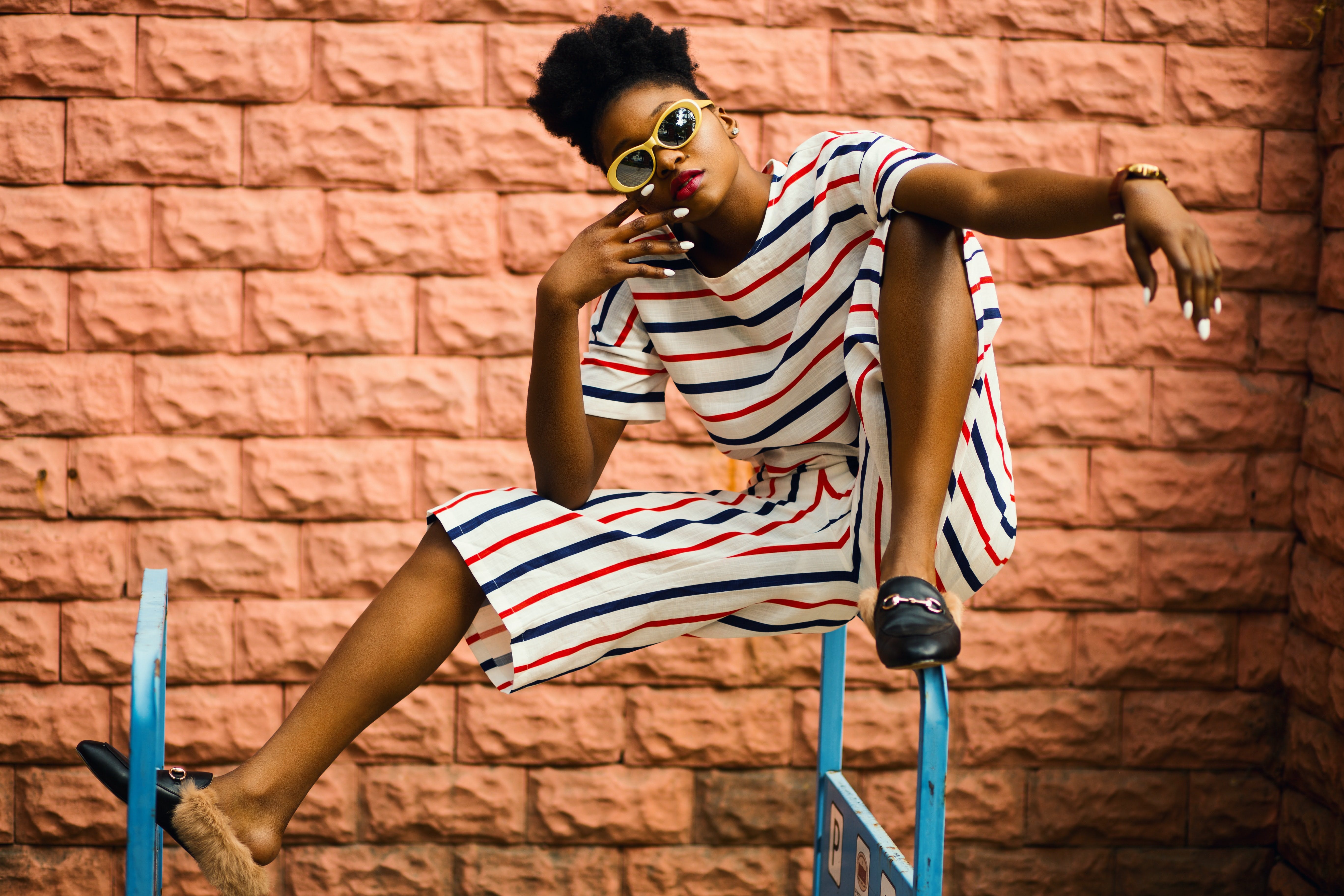 Model posing with a brick wall in the background