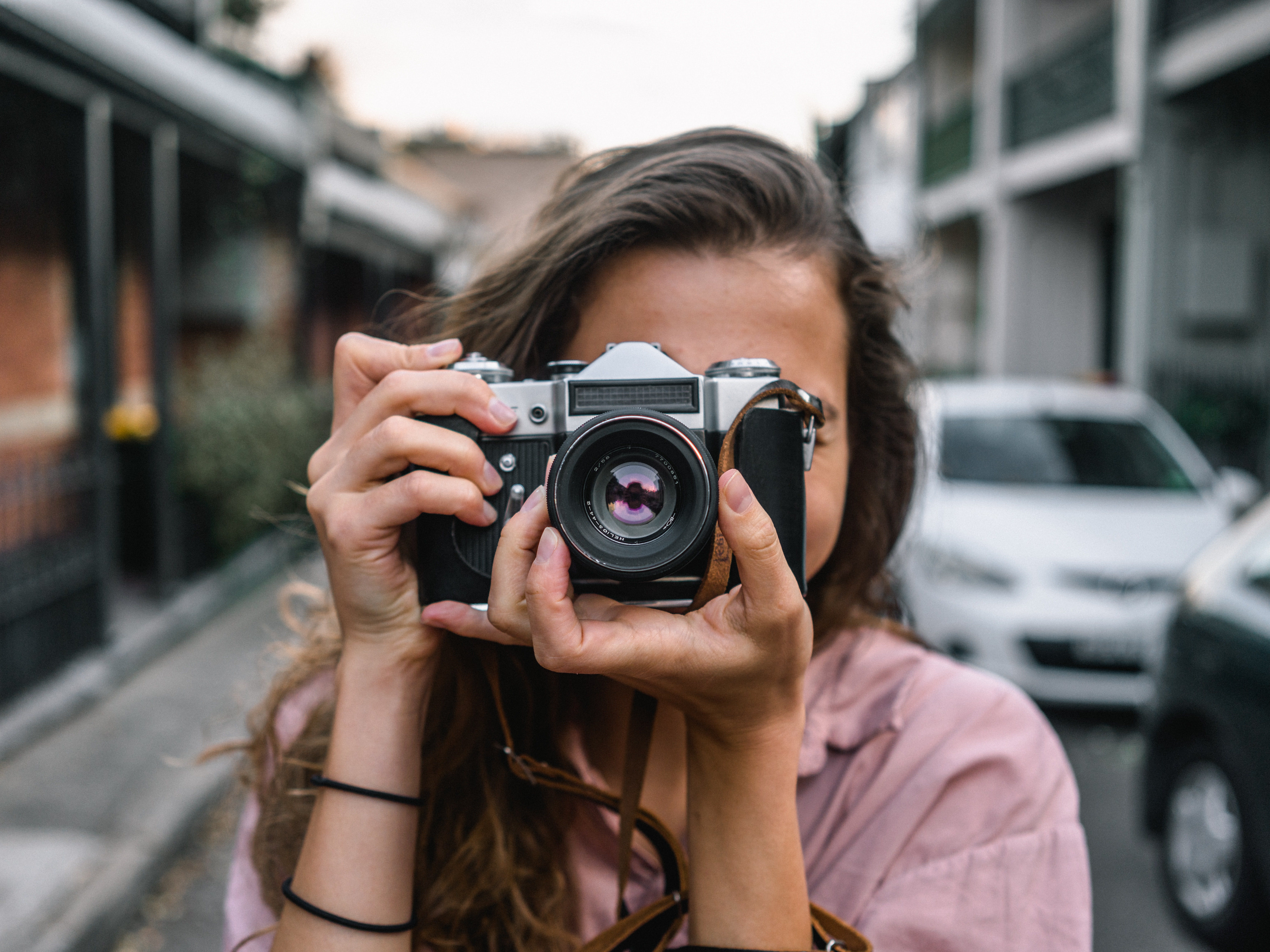 Woman holding a camera pointing at the screen and taking a picture 