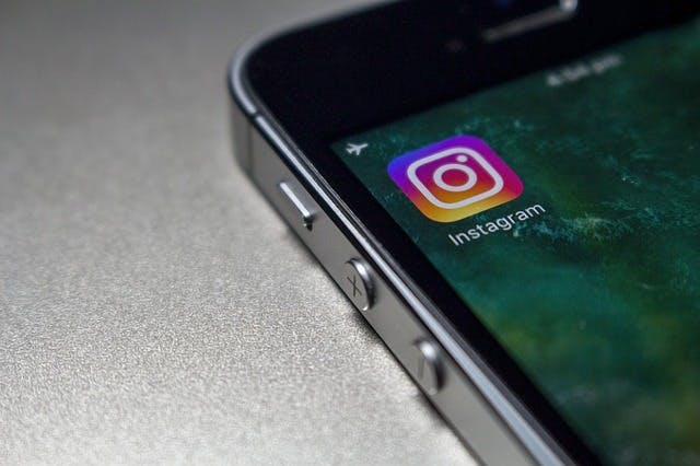 An iPhone 4 showing the instagram app logo