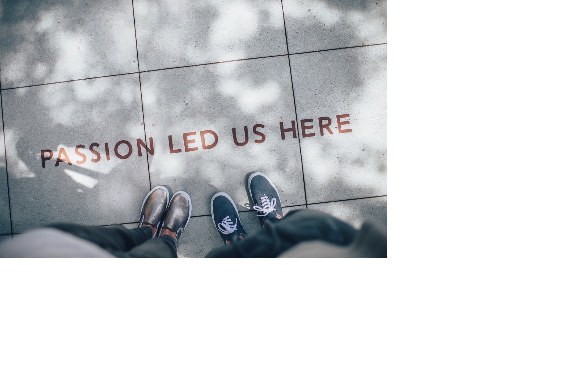 Two people standing on a road and in front of them there is a text on the road that says: 'Passion led us here'